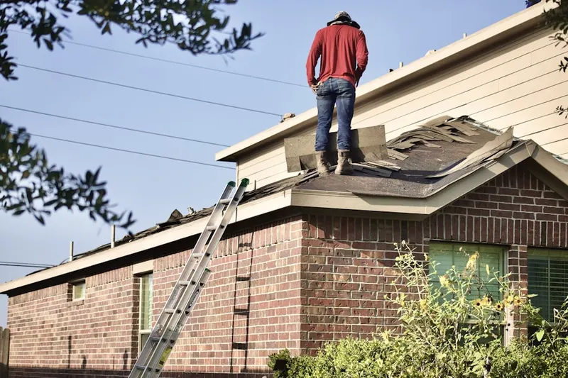 Professional roofer working on a residential roof in Harleston Village